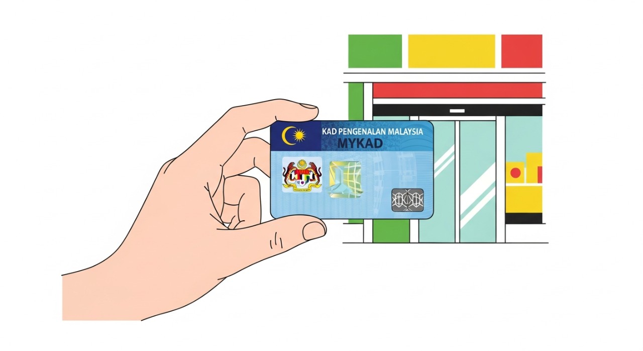 Tangan seseorang sedang memegang kad pengenalan MyKad di hadapan sebuah kedai runcit.